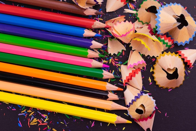 Potloden van verschillende kleuren op een zwarte achtergrond bovenaanzicht heldere achtergrond van potloden