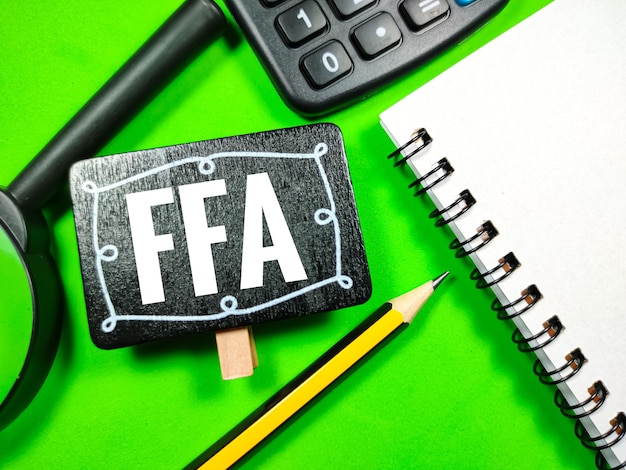 Potloodvergrootglascalculator en notitieboekje met tekst FFA Free Fatty Acids op groene achtergrond