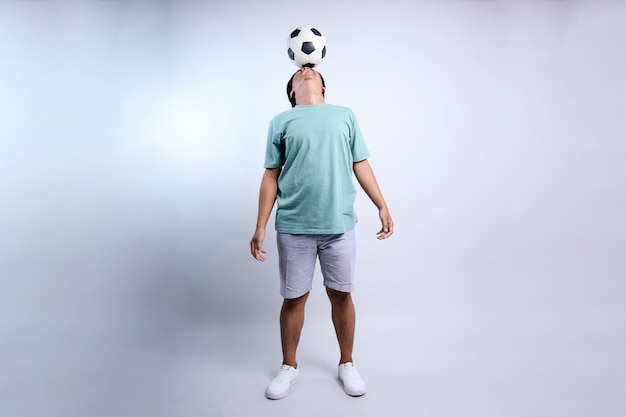 초상화 젊은 아시아 남자 팬 캐주얼 옷 셔츠 응원 축구 팀 축구 공을 치
