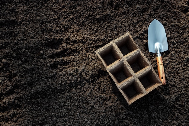 Pots for seedlings and a small spatula on the ground.