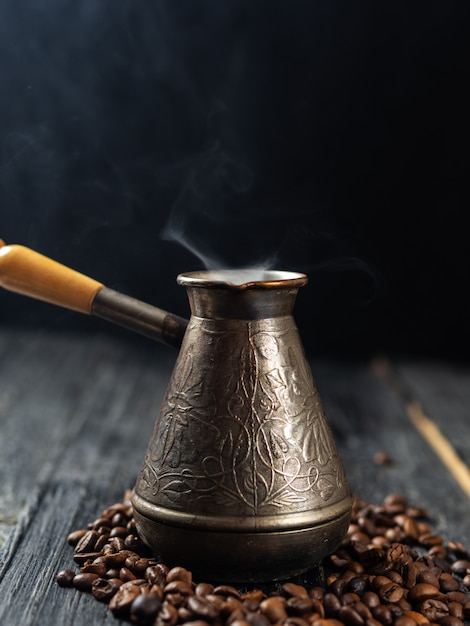 Pots with freshly brewed coffee on a dark background with smoke