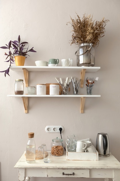 Горшки с различными комнатными растениями и разнообразной посудой