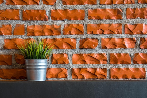 Potted plant on counter against brick wall