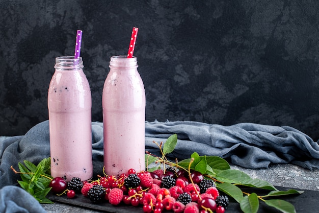 Potten van milkshake met veenbessen, aardbeien en bosbessen