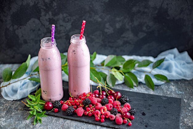 Potten van milkshake met veenbessen, aardbeien en bosbessen