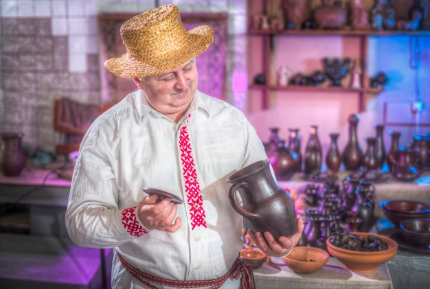 Pottenbakker met kruik staat in zijn werkplaats