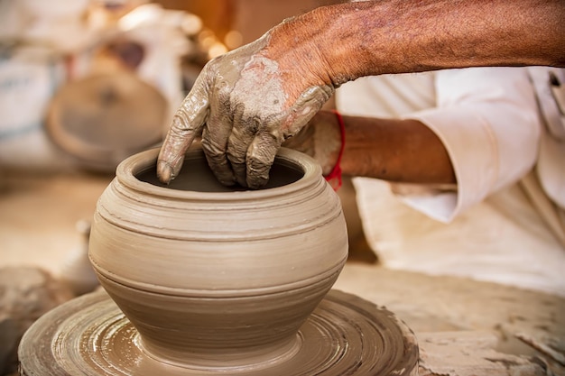 Potter at work maakt keramische gerechten. Indië, Rajasthan.