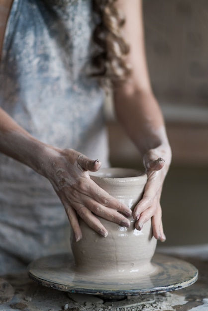 Potter beeldhouwt een vaas op een pottenbakkerswiel