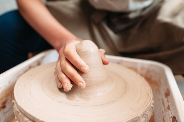 Potter hand on wheel with clay