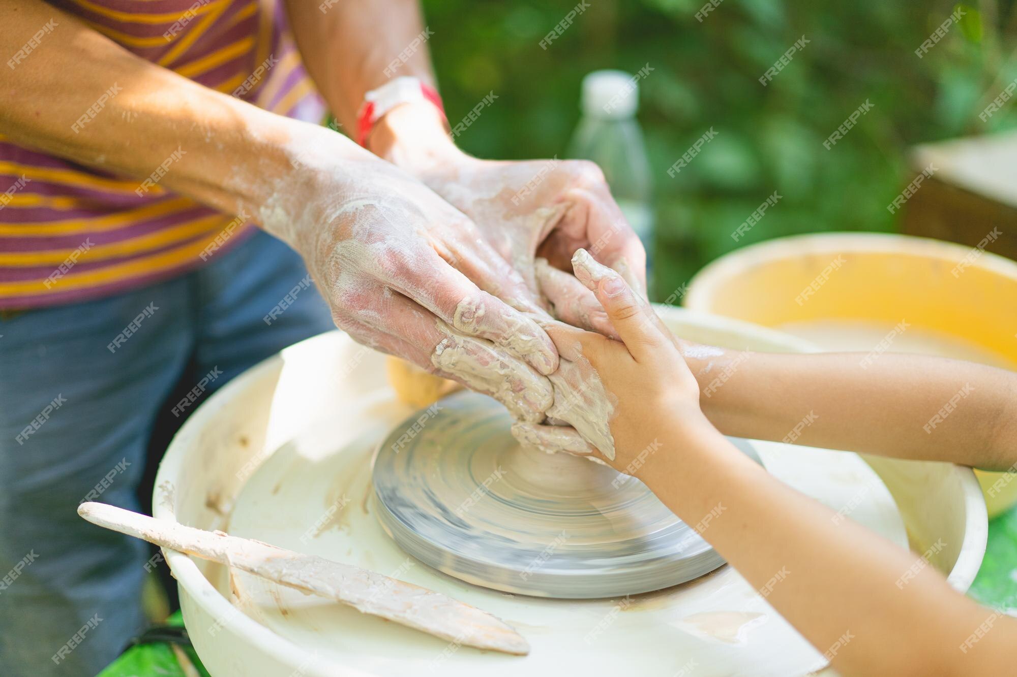 Premium Photo  Potter making a clay object on pottery wheel in