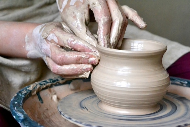 Potter making vase from clay