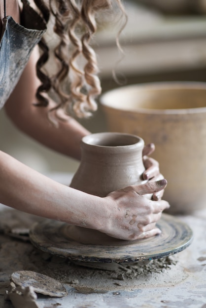 Potter sculpts a vase on a potter's wheel