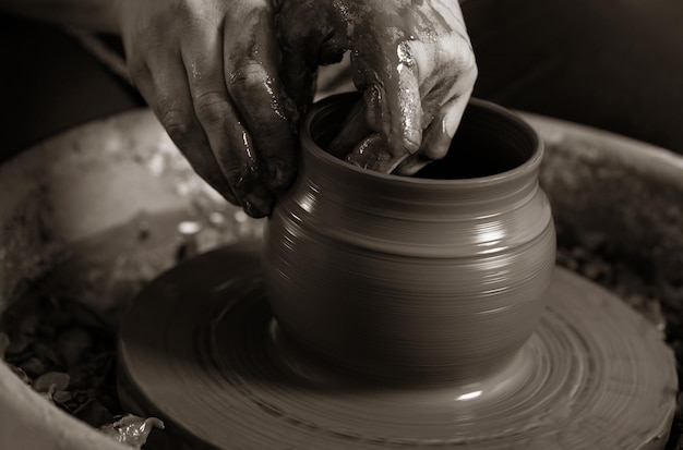 Potter shaping clay on the pottery wheel