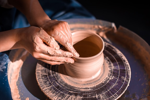 Potter woman hands creating dishes