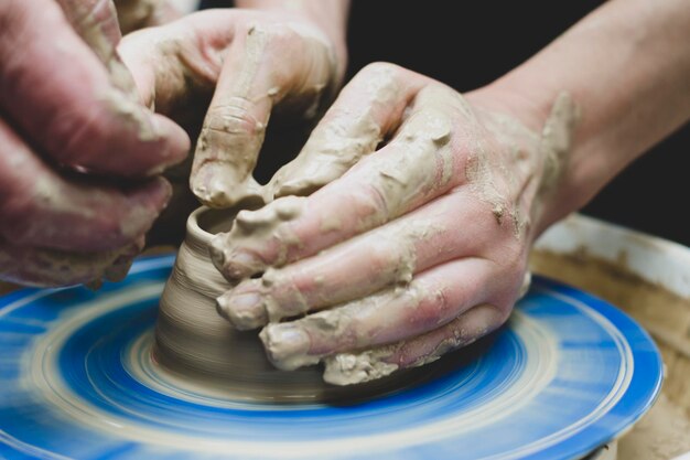 Potter at work makes a jug out of clay pottery workshop