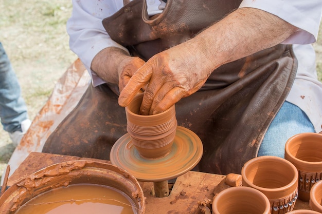 粘土を形作る陶工の手