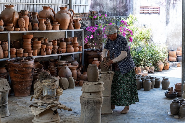 a pottery artist create traditional handicraft clay vase in Bau Truc pottery village Using traditional techniques