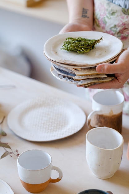 陶器事業。手工芸品の手作り生産。ワークショップでのクラフト食器と粘土プレートの職人の品揃え