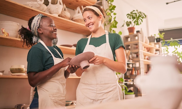 Foto affari di ceramica e donne felici in officina insieme a un sorriso entusiasta per il processo creativo e lo sviluppo collaborazione della felicità e abilità del team di artisti interrazziali nell'area di lavoro