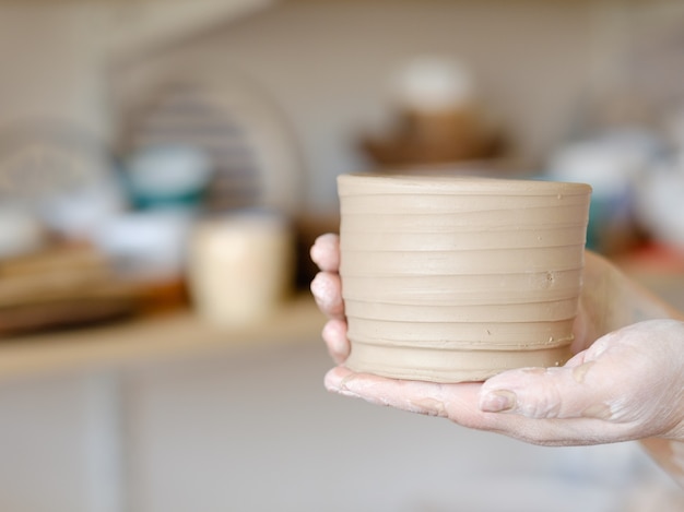 Pottery handcraft hobby. hands showing freshly made crock pot