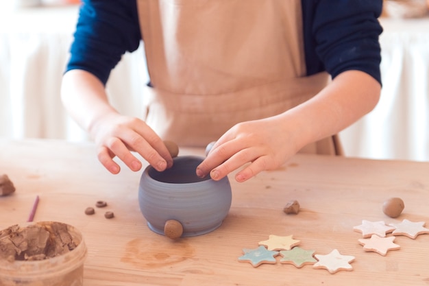 粘土で働く子供たちの女の子のための陶器のワークショップ