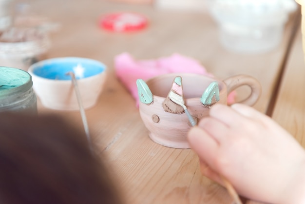 Photo pottery workshop for kids girl working with clay