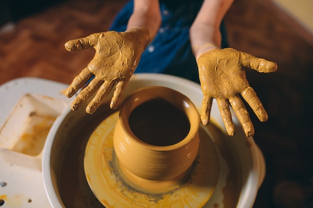 Laboratorio di ceramica. una bambina fa un vaso di argilla. modellazione di argilla