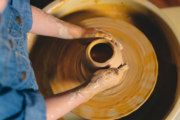 Pottery workshop. A little girl makes a vase of clay. Clay modeling