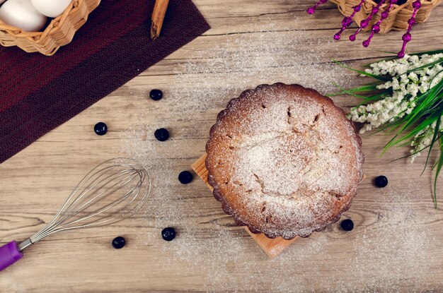 Pound cake on wooden table decorated with blueberries around