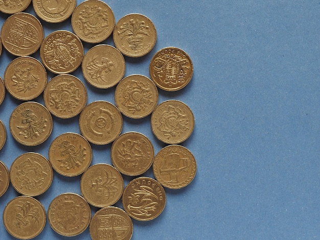 Pound coins, United Kingdom over blue with copy space