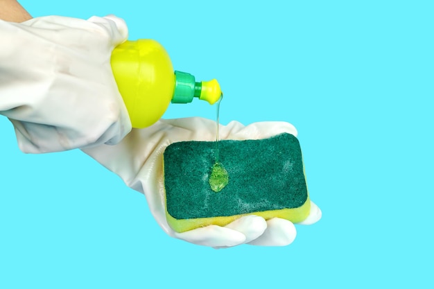 Pour the dishwashing liquid into the dishwashing sponge on blue with clipping path.