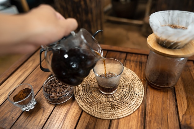 Pour hot water into coffee.,drip coffee on a wooden table at home