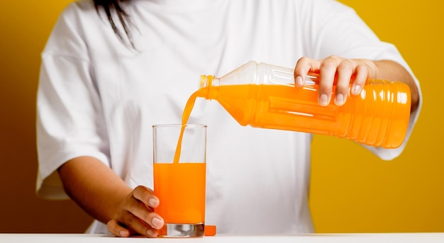 Pour the orange juice from the bottle into the orange juice glass and drink healthy orange juice