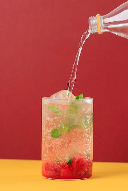 Pour Soda Sparkling Water to the Glass with Strawberry Mojito