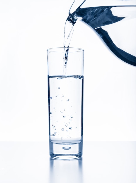 Налейте воду из кувшина в стакан