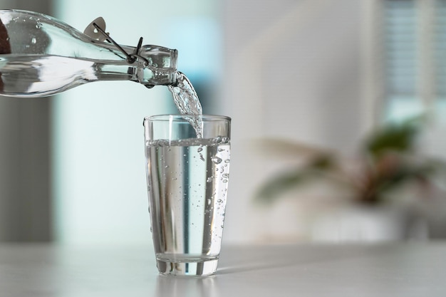 Pour the water from the water bottle into the glass