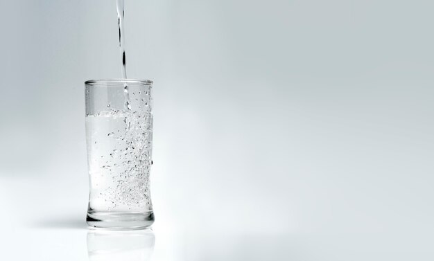 pour water into the glass on a white background