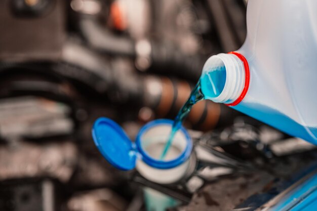 Pouring antifreeze Filling a windshield washer tank with an antifreeze in winter cold weather