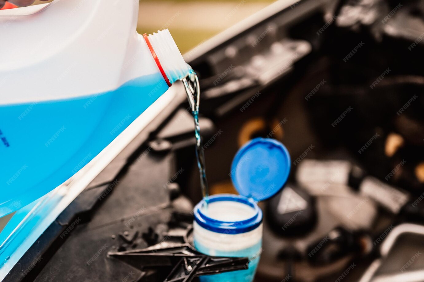 Premium Photo Pouring antifreeze filling a windshield washer tank with an antifreeze in winter