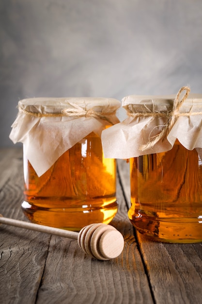 Pouring aromatic honey into jar, closeup.