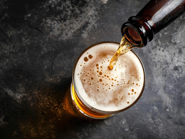 Photo pouring beer from beer bottle in glass serving in a dark background top view angle