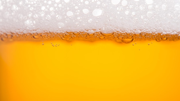 Foto birra di versamento con schiuma di bolle in vetro per lo sfondo