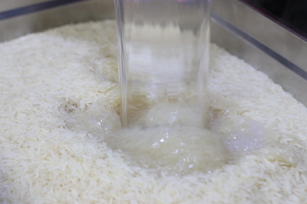 Pouring Boiling Water onto Pot Filled with Rice to Cook it