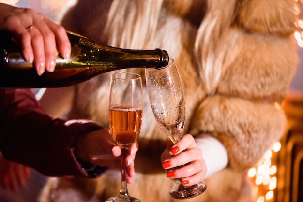 パーティーでグラスにシャンパンを注ぐ、クローズアップ、冬