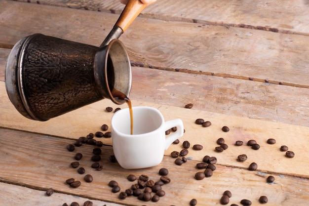 Pouring coffee to white cup, seed around