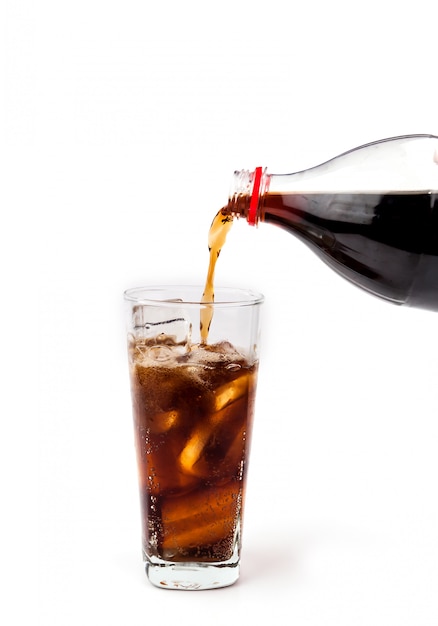 Photo pouring cola drink in glass with ice on white background