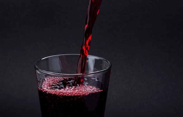 Pouring cola drink on a glass