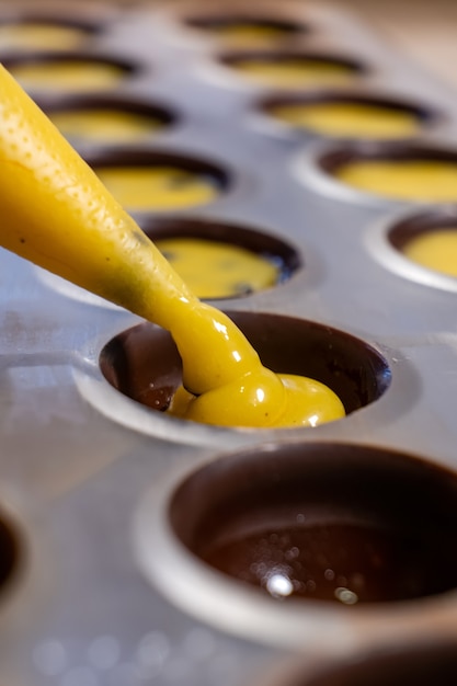 Photo pouring the filling into candies during the manufacturing process.