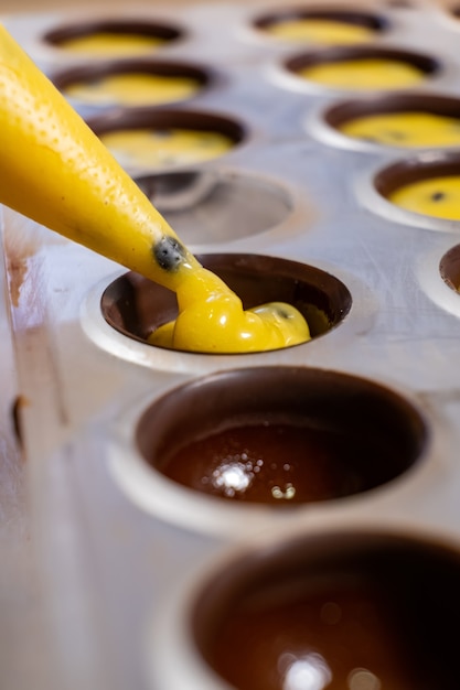 Pouring the filling into candies during the manufacturing process.