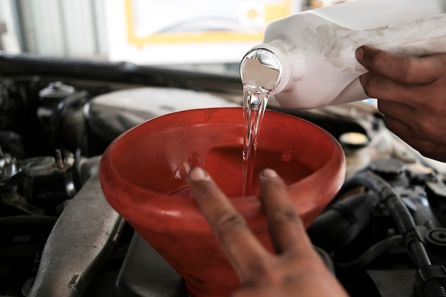 Pouring flushing oil to clean car engine